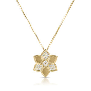 Gold necklace with a diamond-studded pendant shaped like a cluster of chevrons and geometric petals, hanging against a white background
