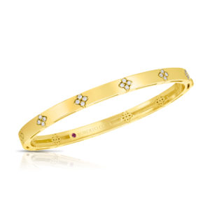 Gold bracelet with flower-shaped diamond accents, shown diagonally against a white background. engraved brand visible on inner band.