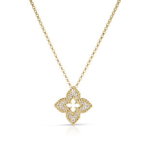 Gold necklace with a diamond-studded pendant featuring a decorative cross-like shape hanging against a white background, with a subtle reflection beneath.