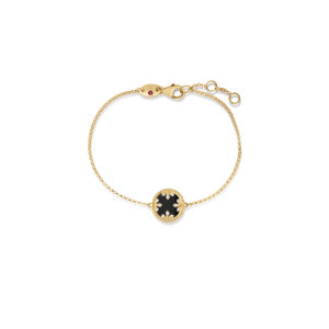 Gold bracelet with a black circular charm encrusted with diamonds on a delicate chain