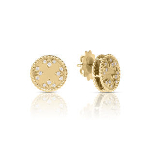 Two gold circular filigree jewelry pieces with embedded clear stones, shown against a white background and reflected beneath.