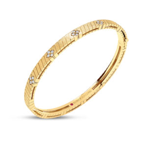 Gold bracelet with brushed rectangular links and small diamond flower clusters along the band, shown curved against a white background.
