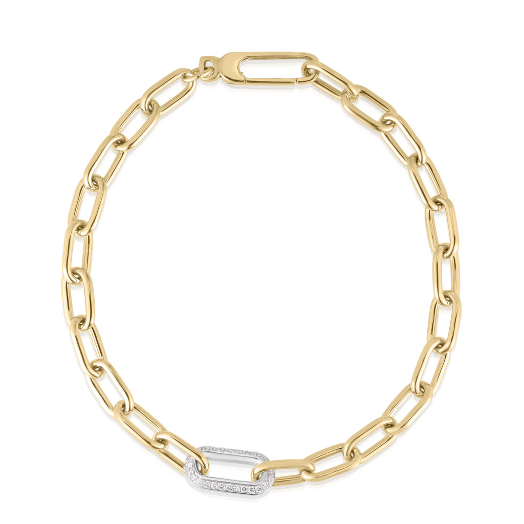 Close-up of a gold chain necklace with a diamond-studded link against a white background